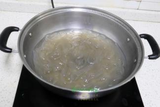 把煮锅清洗干净，倒入适量的冷水煮沸，接着把过冷水的粉条倒入锅里再次煮沸，把粉条煮熟。