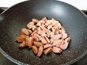 锅里放入食用油烧制三层热，下入牛肉肠翻炒。