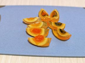 首先将皮蛋对半切，再取一半从中间切开。