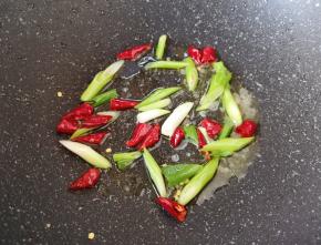 锅底留余油，下入小葱和干红辣椒炒香。