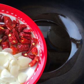 锅内放油，倒入葱蒜和辣椒段爆香