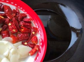 锅内放油，倒入葱蒜和辣椒段爆香