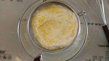 低粉和玉米粉混合均匀后筛入油和奶混合物内，用打蛋器“Z”字形刮拌均匀。