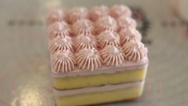 表面再抹好一层树莓奶油，剩余的用装有18齿的裱花嘴挤出奶油装饰。