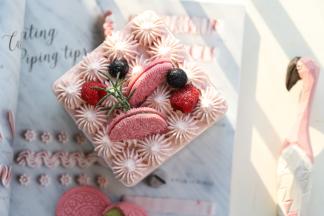 摆放上新鲜的树莓和蓝莓，迷迭香和粉色奥利奥饼干装饰。