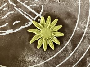 用模具压出草莓蒂的形状，如果没有模具，可以擀出一片小圆面片，用剪刀把圆片剪一圈小片，边上用手捏尖。