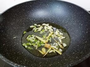 锅里倒入食用油，油温三层热下葱姜蒜炒香。