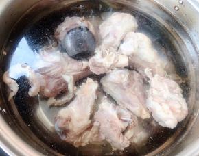 锅中添加适量清水放入筒骨和调味盒同时放入糖和料酒大火煮起来，煮至筒骨熟透而不软烂