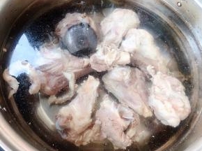 锅中添加适量清水放入筒骨和调味盒同时放入糖和料酒大火煮起来，煮至筒骨熟透而不软烂