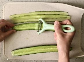 用刮皮器把黄瓜刨成长片状。
