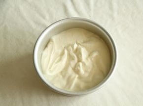 从高处倒入六寸模具中。八分满。左右晃下模具，面糊自然晃平了。然后提起模具，离桌面20公分处放手，震2下震出大气泡。