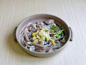 首先将鱿鱼须洗干净放入器具中，加入切好的葱姜蒜，抓拌均匀。