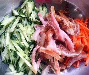 猪耳晾凉切丝胡萝卜和黄瓜都切成丝放入容器中