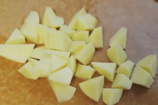 1.炸薯角，最好用黄心土豆，做出来的薯角内部才会特别软糯，把黄心土豆的外皮用削皮刀刮去，然后切成滚刀块