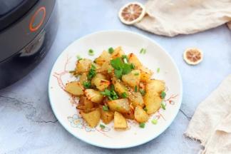 7.烤好的薯角取出来装盘，趁热撒上一层熟芝麻提香，撒上一层小葱碎提味即可