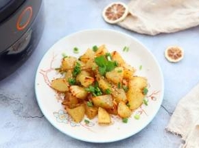 7.烤好的薯角取出来装盘，趁热撒上一层熟芝麻提香，撒上一层小葱碎提味即可