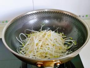 起油锅，加入蒜末炒香，再加入豆芽煸炒。