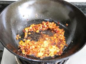 倒入生姜粒、大蒜粒煸炒出香味后倒入郫县豆瓣酱煸炒出红油，翻炒均匀后倒入虾黄煸炒一会儿；