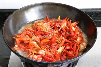 大火烧开后倒入之前炸好的小龙虾；