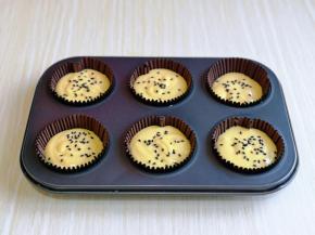 依次将蛋糕糊挤入纸杯中，撒上黑芝麻。