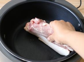 猪肉洗净擦干水分，皮朝下放入烧热冒烟的锅中烫成金黄色，这样做是为了去除皮上的毛，也为了去掉腥味；