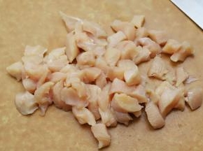1.准备一块干净的鸡胸肉，用刀背拍松，然后切成大约一厘米见方的小块