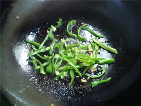 接着下青椒，翻炒几下，炒至青椒断生。