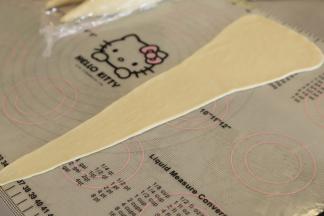 用擀面杖擀成倒三角形，长度10厘米，高度为35厘米。