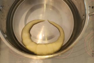 准备一个盆，先倒入40度的温水，再倒入烘焙碱，带上塑胶手套（一定要），将普雷结放入碱水内，泡20秒后翻面再泡20秒，捞出沥干水分。