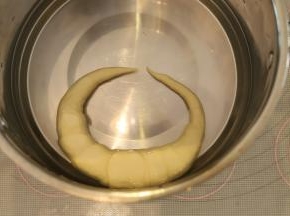 准备一个盆，先倒入40度的温水，再倒入烘焙碱，带上塑胶手套（一定要），将普雷结放入碱水内，泡20秒后翻面再泡20秒，捞出沥干水分。