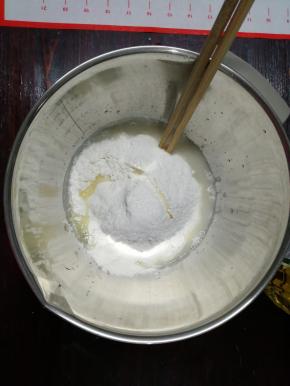 1、盆里倒入温水，酵母倒入，用筷子搅拌至酵母溶化，把面粉、玉米油、糖和盐都倒入盆中