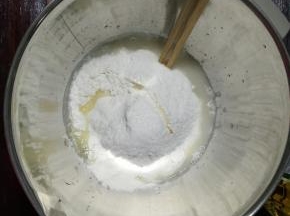 1、盆里倒入温水，酵母倒入，用筷子搅拌至酵母溶化，把面粉、玉米油、糖和盐都倒入盆中