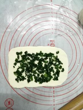 把小面团用擀面棍擀成长方形（未操作的面团先盖上保鲜膜，防止风干），擀好的面片尺寸大概是10*15CM，有的人说很难擀成这个形状，你只要上下擀，每个角都向外擀开，这个也需要多练习。在长方形面片上撒上馅料，四周不要撒料