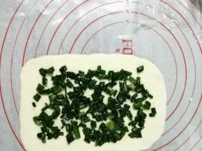 把小面团用擀面棍擀成长方形（未操作的面团先盖上保鲜膜，防止风干），擀好的面片尺寸大概是10*15CM，有的人说很难擀成这个形状，你只要上下擀，每个角都向外擀开，这个也需要多练习。在长方形面片上撒上馅料，四周不要撒料