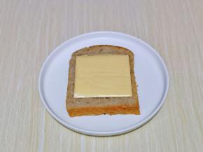 取一片 吐司，放上芝士片。