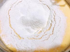 分两次筛入混合好小苏打和泡打粉的糕点粉，用刮刀翻拌均匀无面粉颗粒