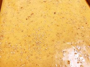 把面糊倒入垫了油纸或者硅胶垫的三能金盘里，撒上白芝麻