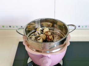 再把蒸屉放上，加入洗好的鹌鹑蛋。