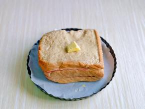 早上起来，蛋奶液已经完全被吐司片吸收啦！烤盘掉油纸，吐司放烤盘里，上面放上一块黄油。