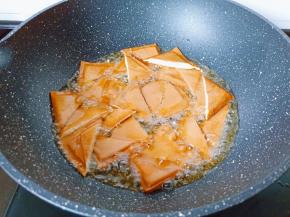 锅中倒油烧至五成热下豆炸至金黄色，捞出后沥干油。