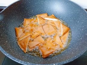 锅中倒油烧至五成热下豆炸至金黄色，捞出后沥干油。