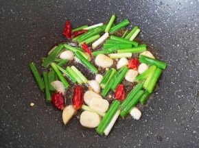 锅里继续倒入食用油烧热，下入葱、蒜和干红辣椒炒香。