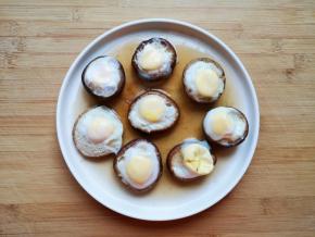 蒸熟的香菇鹌鹑蛋从蒸锅里取出，将香菇移至另外一个盘子里。