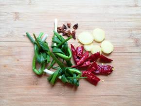 小葱洗干净打成结，干红辣椒掰开，生姜切成片，准备好八角。

