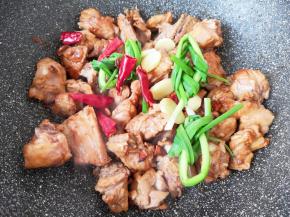 加入小葱、干红辣椒、八角和生姜炒香。