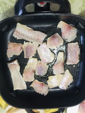 电热锅加热，放入适量的油，再放入鱼片和鱼骨！小火慢烤！