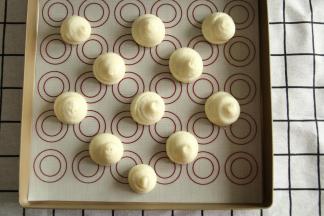 裱花嘴垂直悬空，挤出11-13个直径3.5厘米的圆球形。挤完顶部略按一下，或者手指蘸水按平。防止烤出来有凸出。挤了11个，有几个挤的大了一些，一定要距离远一些，会膨胀的。