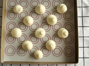 裱花嘴垂直悬空，挤出11-13个直径3.5厘米的圆球形。挤完顶部略按一下，或者手指蘸水按平。防止烤出来有凸出。挤了11个，有几个挤的大了一些，一定要距离远一些，会膨胀的。