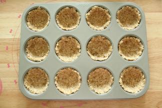 此时预热烤箱上下180度。然后取出12连模（我家人多，所以做的量多了一些）。每个里面取一大勺，用勺子或者带上PVC手套沿着模具按压均匀成杯子状即可（不要压太厚）。