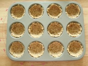 此时预热烤箱上下180度。然后取出12连模（我家人多，所以做的量多了一些）。每个里面取一大勺，用勺子或者带上PVC手套沿着模具按压均匀成杯子状即可（不要压太厚）。